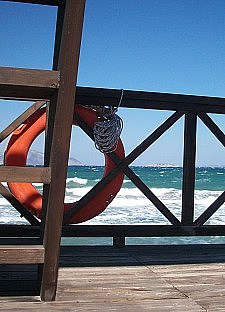Meer mit einem Holzsteg, an dem ein Rettungsring befestigt ist
