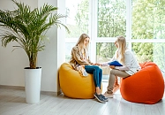 zwei Frauen sitzen sich auf Sitzsäcken gegenüber