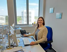 Es ist die Praktikantin am Schreibtisch zu sehen.