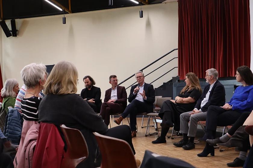 Zu sehen ist ein Stuhlkreis mit Menschen.