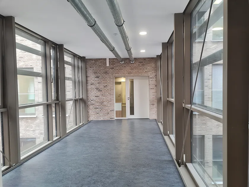 Die Innenansicht. Ein Flur, links und rechts eine Glasfassade