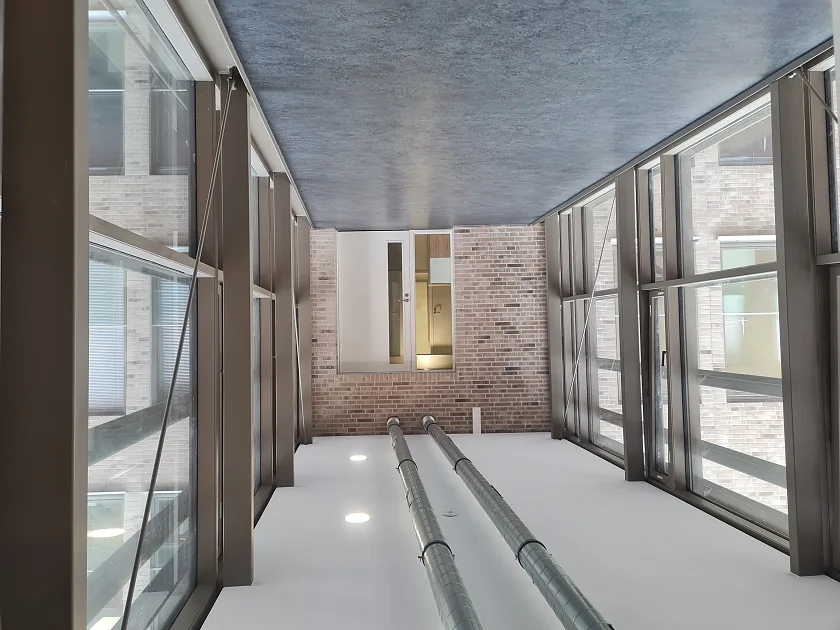 Die Innenansicht. Ein Flur, links und rechts eine Glasfassade