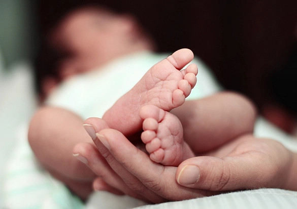 Babyfüße werden in die Kamera gehalten