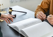 Zwei Menschen unterschreiben in ein Buch.