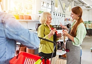 Eine Frau im Supermarkt im Gespräch mit einer Verkäuferin.